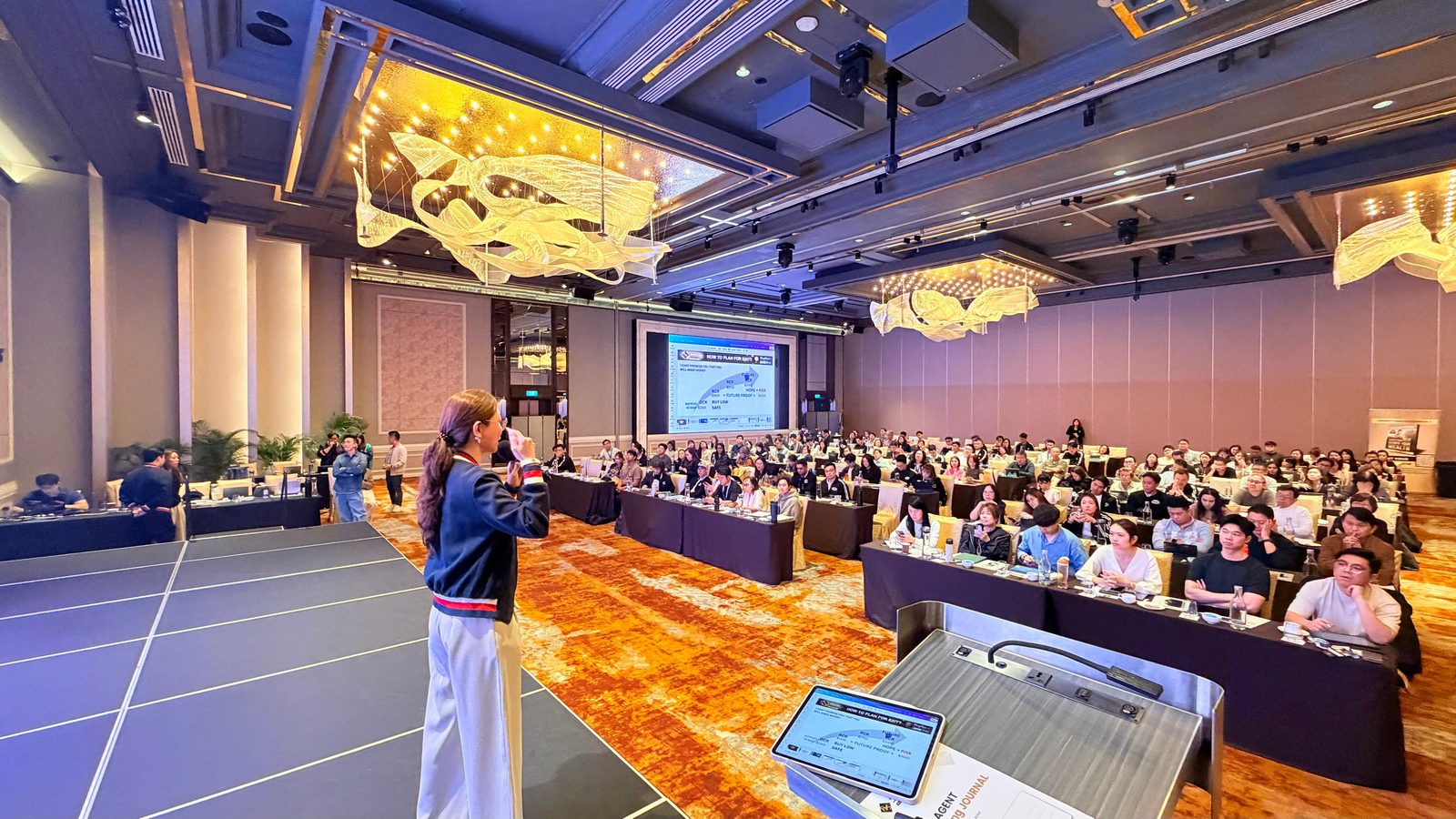 Kelly Lin presenting a property-planning session to a full seminar room of homeowners.